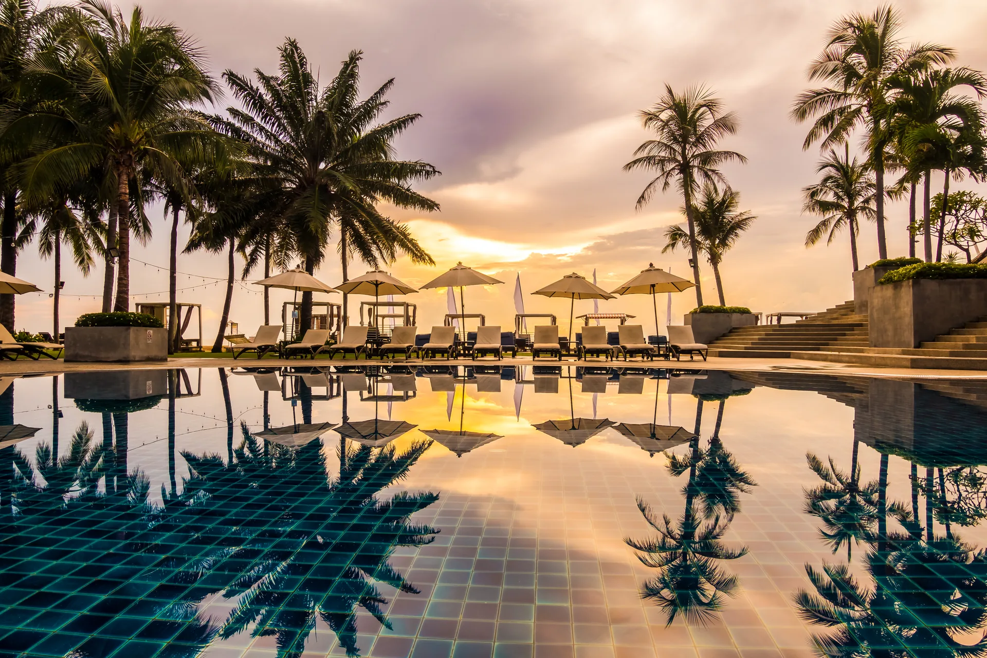 Anjumasa Village: case study · Brand Identity, Siti Web Corporate | FV Digital Agency Piscina con palme al tramonto in un resort tropicale: progetto Anjumasa Village di FV Digital Agency
