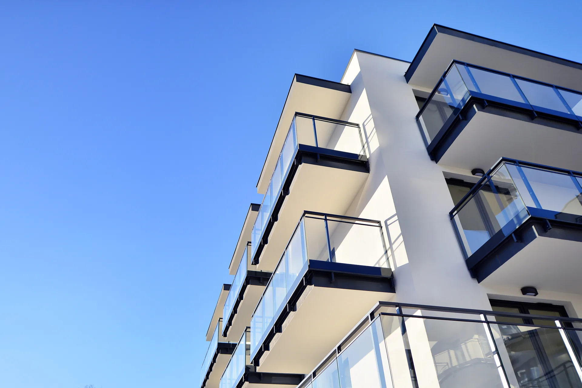 Fidentia Holding: case study · Brand Identity, Graphic Design | FV Digital Agency Palazzina residenziale moderna con balconi contro il cielo: progetto Fidentia Holding di FV Digital Agency