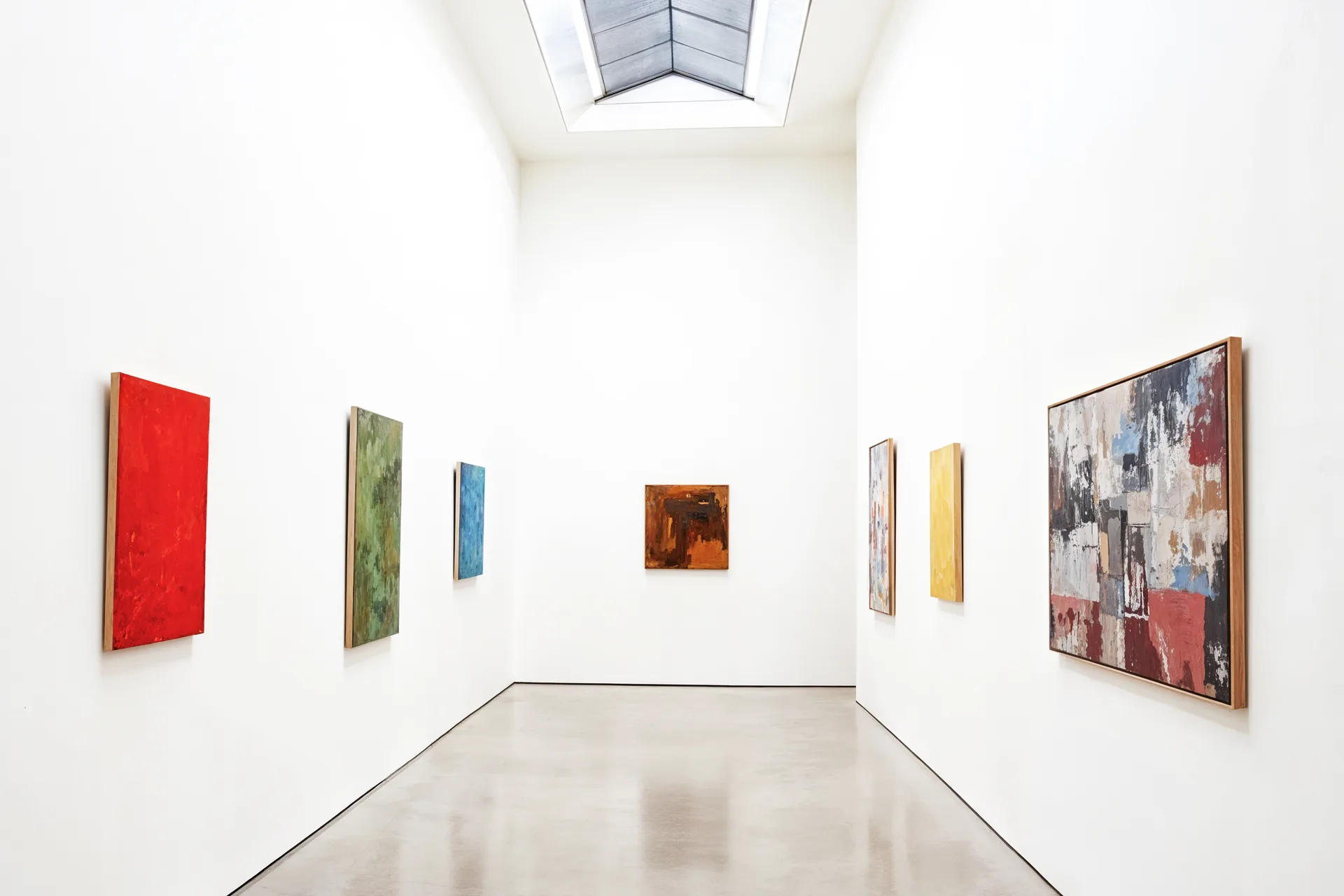 Galleria d'arte con tele astratte colorate su pareti bianche: progetto Ipercubo di FV Digital Agency