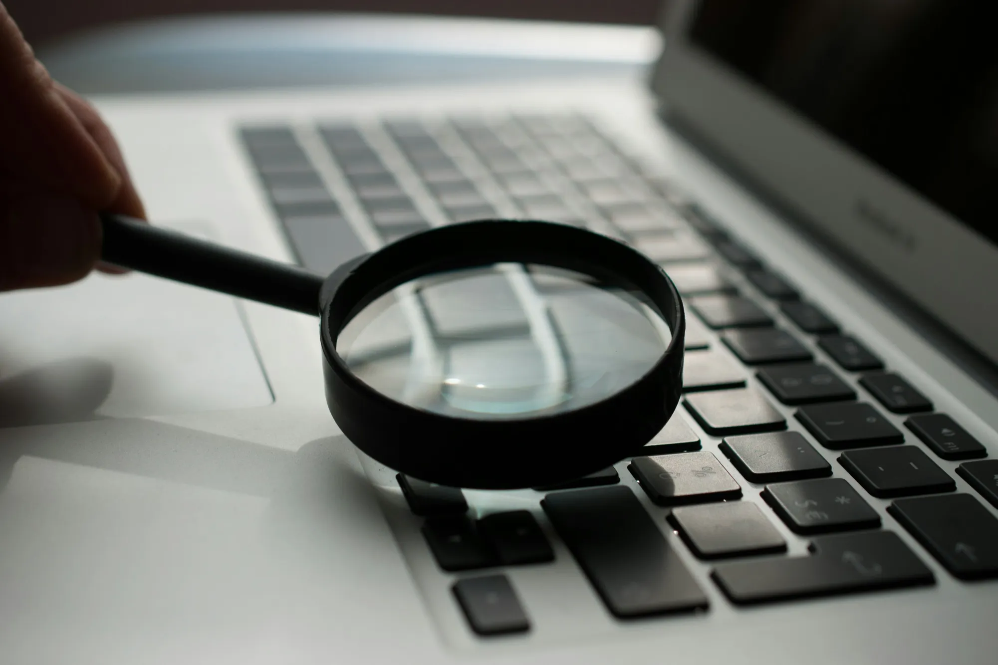 Lente di ingrandimento sulla tastiera di un portatile: SEO e ricerca generativa