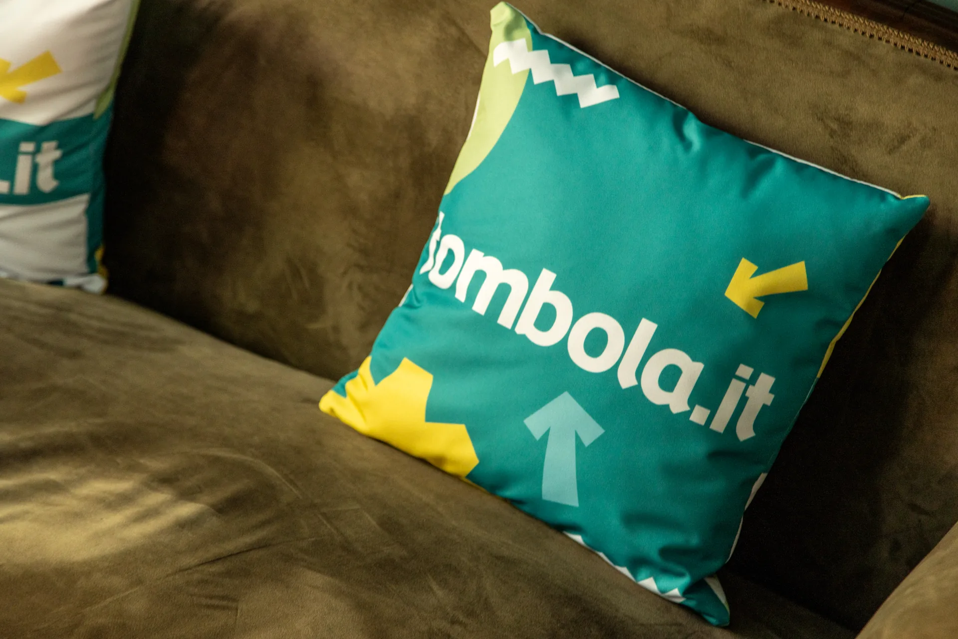 Tombola Italia: case study · Brand Identity, Corporate Communication | FV Digital Agency Cuscino con il logo tombola.it su un divano: progetto Tombola Italia di FV Digital Agency