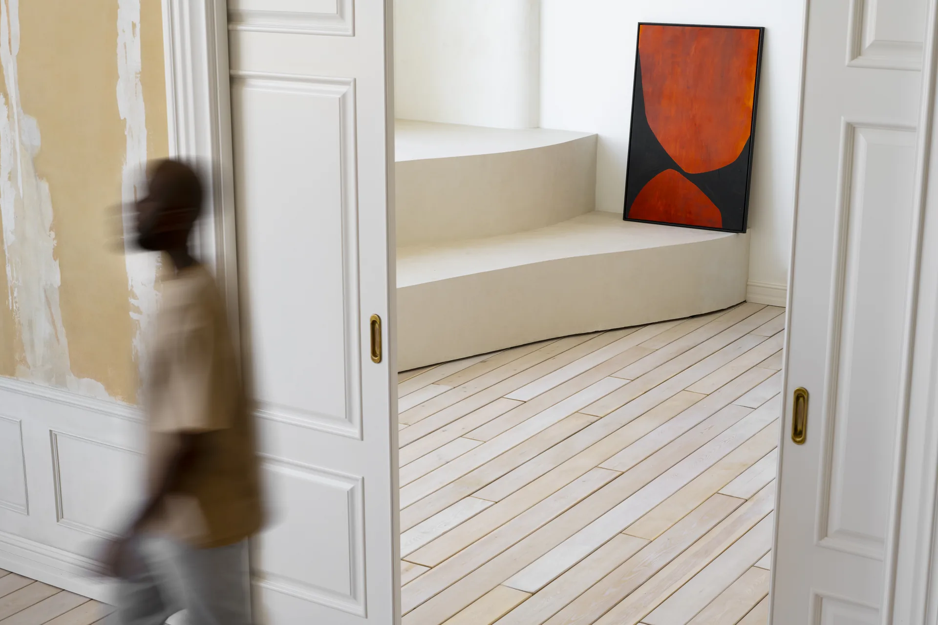 Uomo in movimento in una casa con porte bianche e un'opera d'arte alla parete: progetto Vulcanica Essenza di FV Digital Agency
